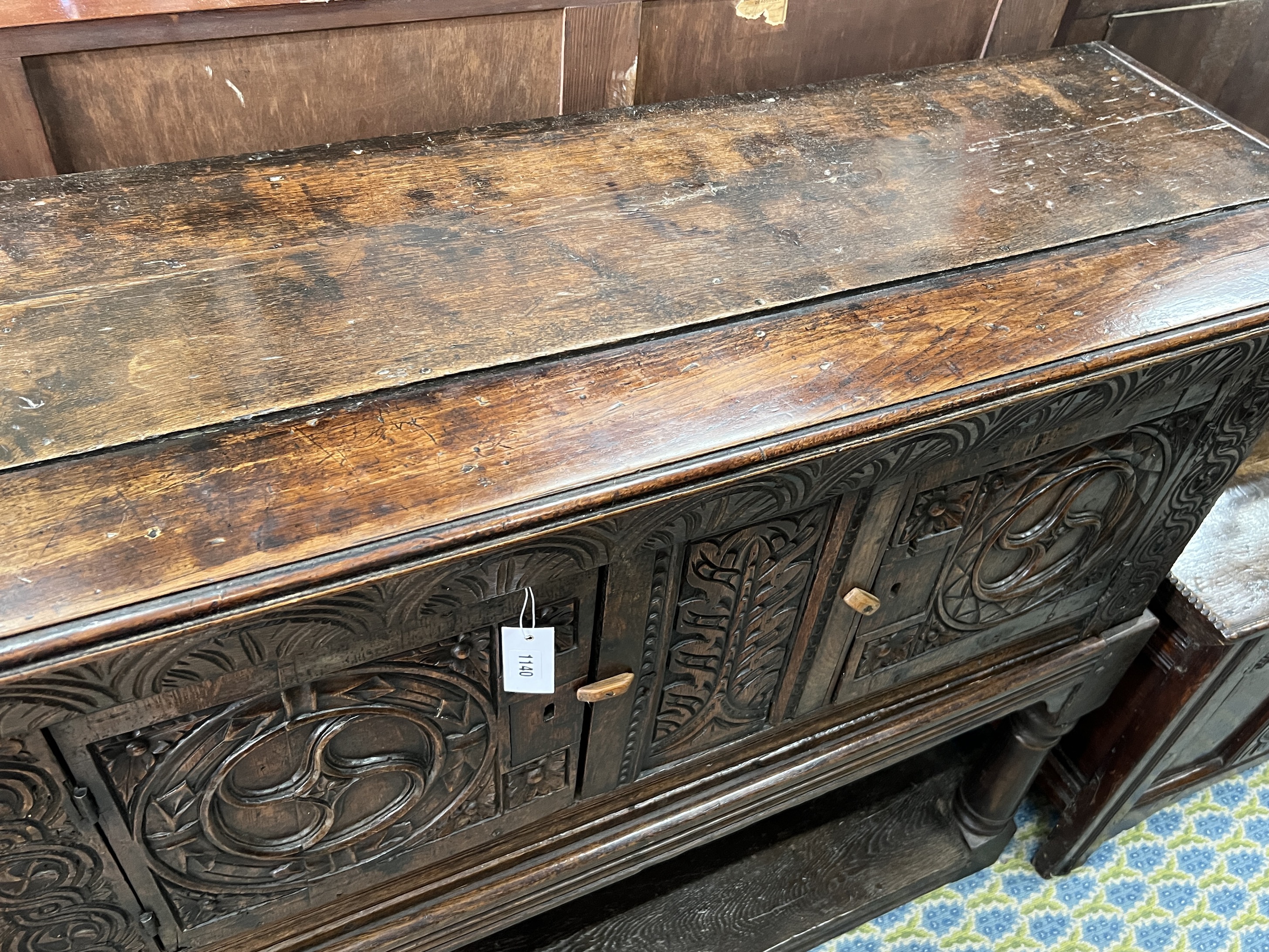 A 17th century and later carved oak potboard cupboard on stand, width 123cm, depth 43cm, height 111cm